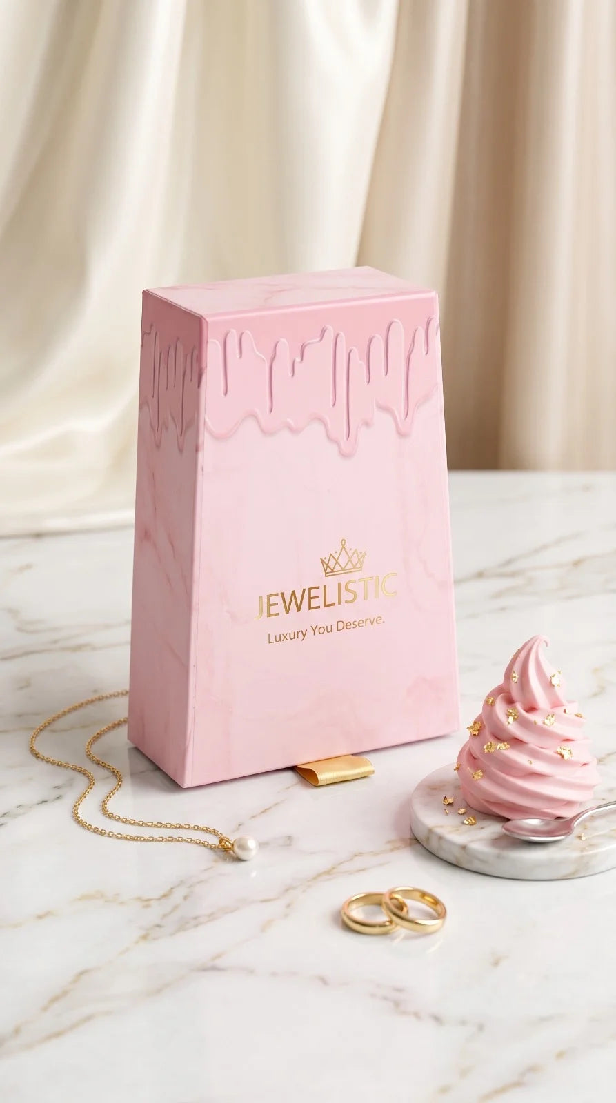Pink jewelry box with gold jewelry on a marble surface