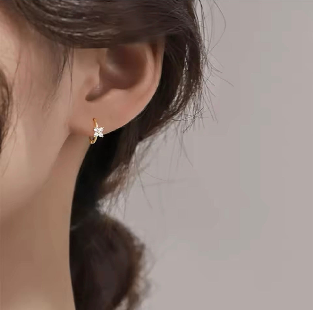 Woman wearing Floral Huggie stacked earrings look