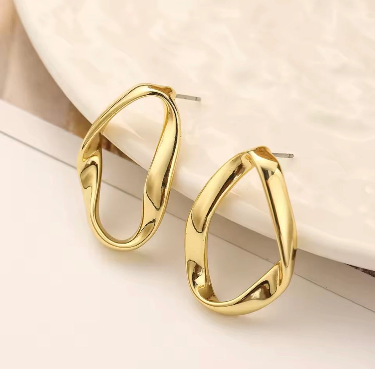 Gold hoop earrings on a light background